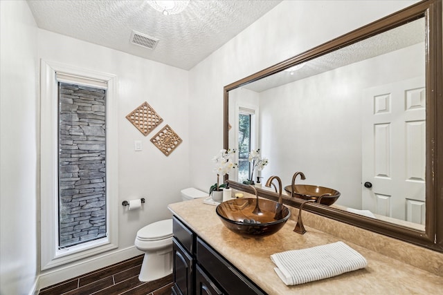 bathroom with vanity, a textured ceiling, and toilet