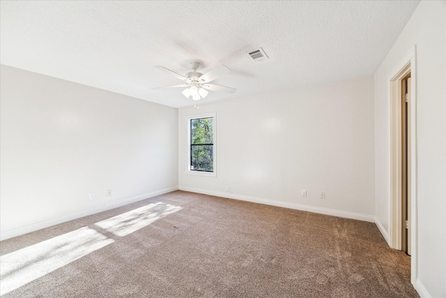 empty room featuring a textured ceiling, carpet floors, and ceiling fan