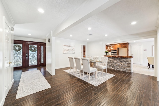 dining area with french doors, ornamental molding, dark hardwood / wood-style floors, and a textured ceiling