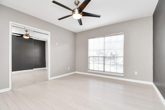 unfurnished bedroom with light wood-type flooring, a closet, and ceiling fan