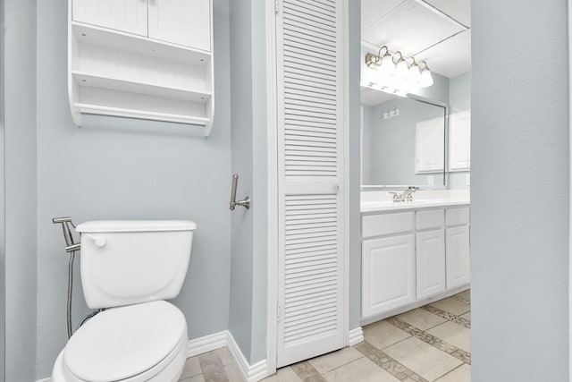 bathroom featuring tile patterned floors, vanity, and toilet