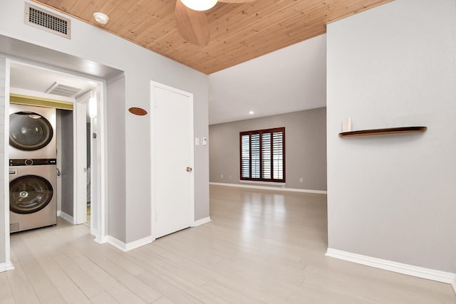 laundry area with wood ceiling, ceiling fan, stacked washer and clothes dryer, and light hardwood / wood-style flooring