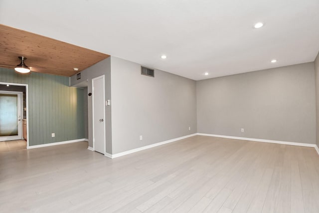 empty room featuring light hardwood / wood-style flooring and wooden walls