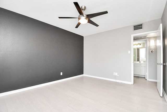 empty room with ceiling fan and light hardwood / wood-style floors