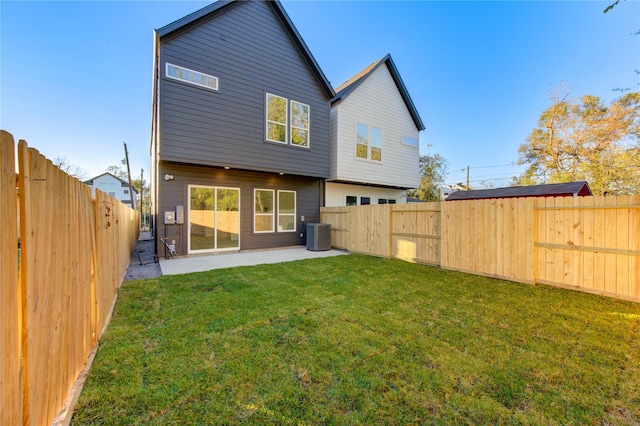 rear view of property with central AC unit, a yard, and a patio area