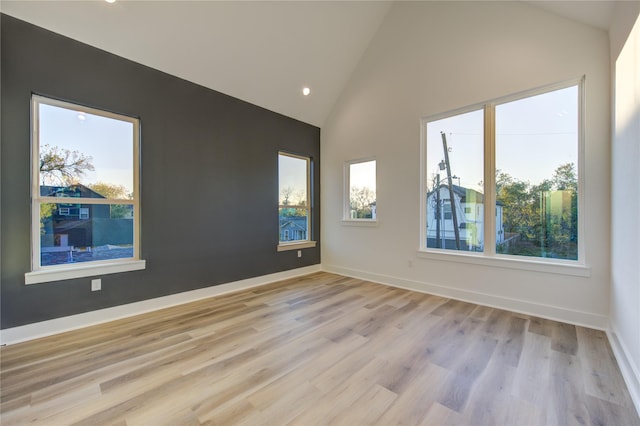 unfurnished room with high vaulted ceiling and light hardwood / wood-style floors