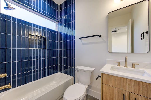 full bathroom with ceiling fan, tiled shower / bath, vanity, and toilet