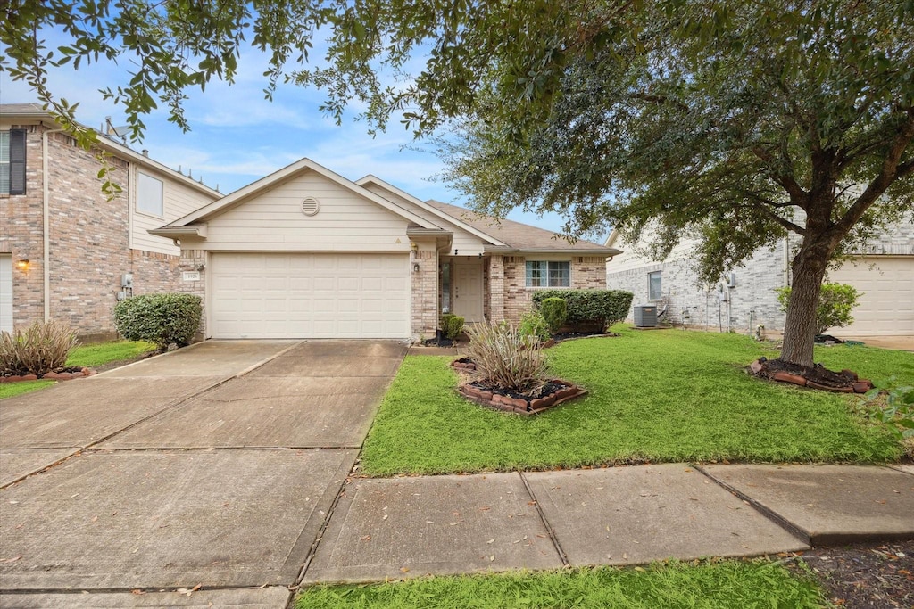 view of front of property with cooling unit, a front yard, and a garage