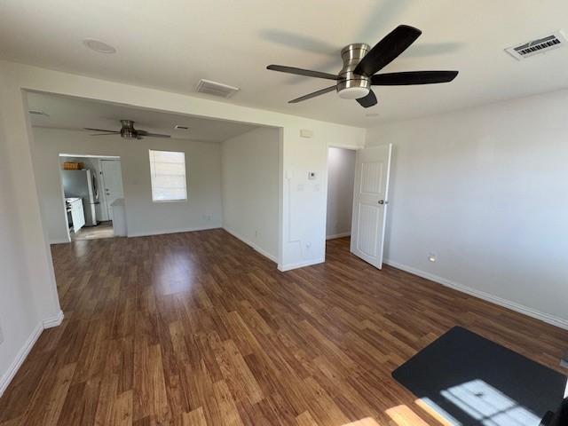 spare room featuring ceiling fan and dark wood-type flooring