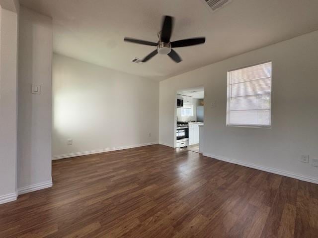 unfurnished living room with dark hardwood / wood-style flooring and ceiling fan