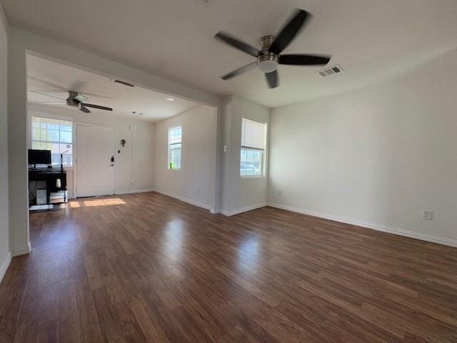 unfurnished living room with dark hardwood / wood-style floors, a healthy amount of sunlight, and ceiling fan