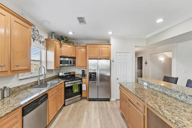 kitchen featuring light stone countertops, sink, stainless steel appliances, light hardwood / wood-style flooring, and a breakfast bar