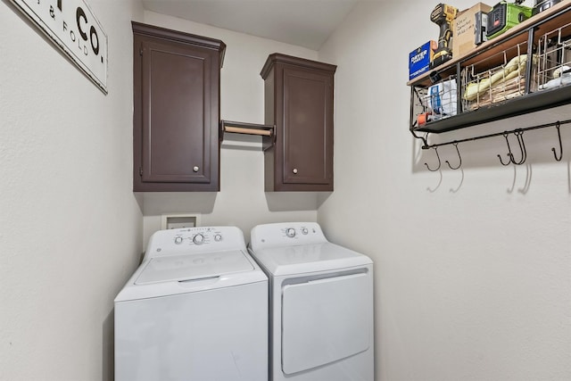 clothes washing area with cabinets and separate washer and dryer