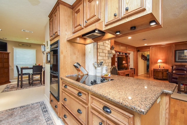 kitchen featuring visible vents, open floor plan, light stone countertops, black appliances, and backsplash