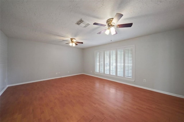 unfurnished room with ceiling fan, wood-type flooring, and a textured ceiling