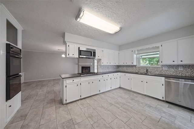 kitchen featuring white cabinets, sink, appliances with stainless steel finishes, and a textured ceiling