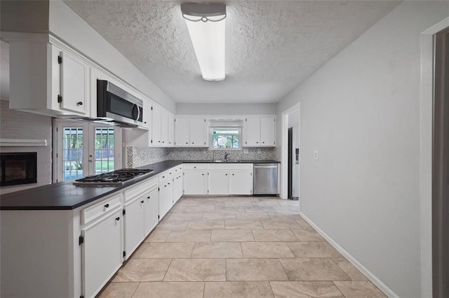 kitchen featuring appliances with stainless steel finishes, a textured ceiling, and white cabinetry