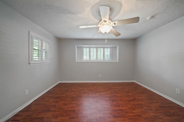 empty room featuring a textured ceiling, ceiling fan, and dark wood-type flooring