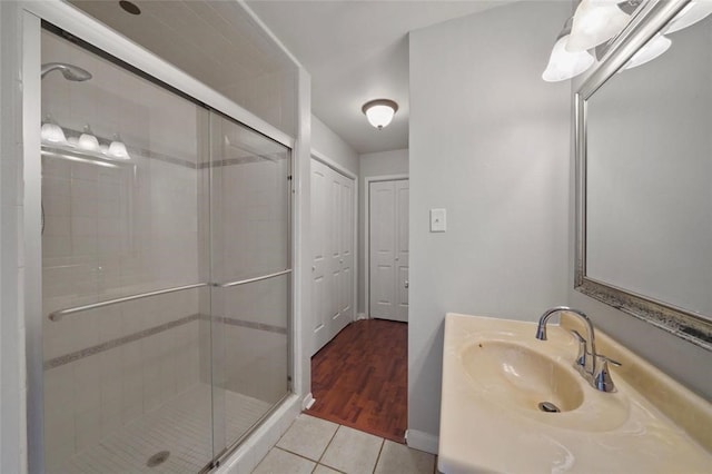 bathroom with tile patterned flooring, vanity, and walk in shower