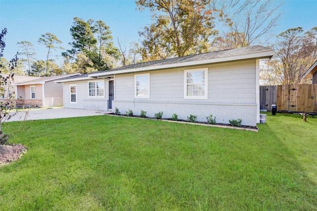 rear view of property featuring a lawn and a patio