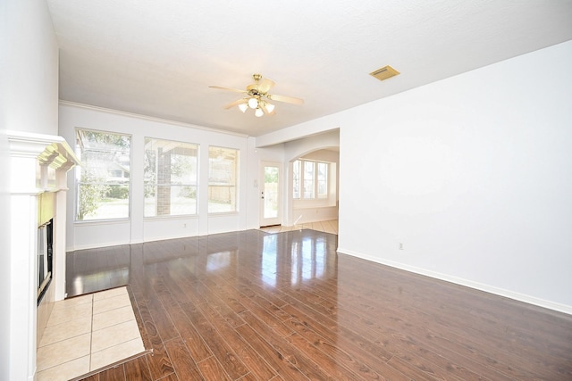 unfurnished living room featuring ceiling fan and dark hardwood / wood-style flooring