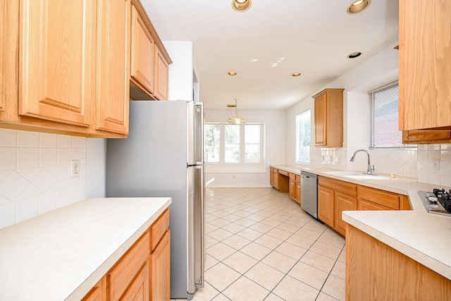 kitchen featuring decorative backsplash, pendant lighting, stainless steel appliances, and sink