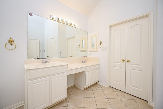 bathroom with tile patterned floors, vanity, and vaulted ceiling