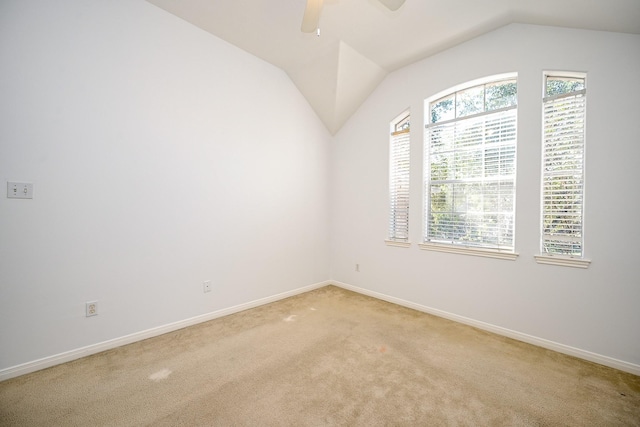 carpeted empty room featuring ceiling fan and vaulted ceiling