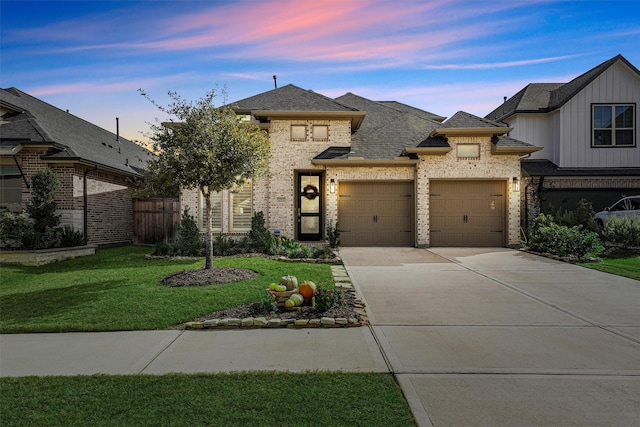 view of front of home with a yard and a garage