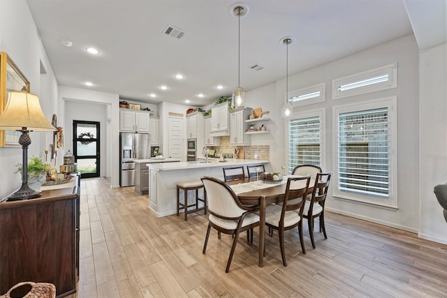 dining space featuring light hardwood / wood-style floors and sink