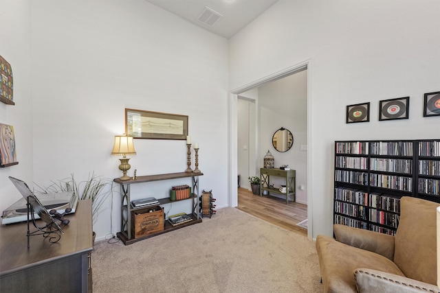 living area with light carpet and high vaulted ceiling