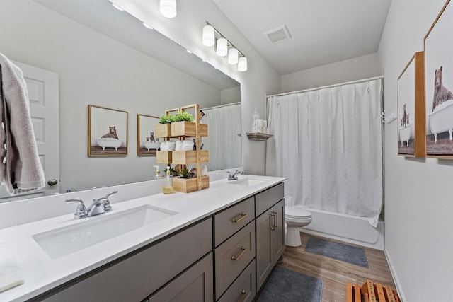 full bathroom with vanity, hardwood / wood-style flooring, toilet, and shower / bath combo with shower curtain