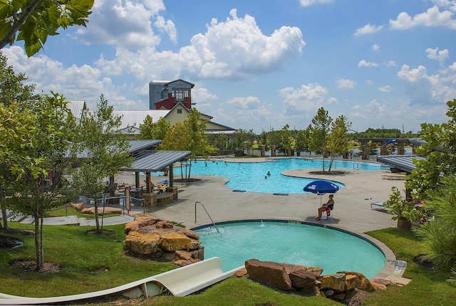 view of pool featuring a lawn and a patio area