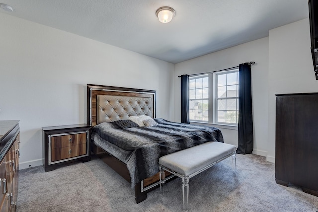 bedroom with light colored carpet and baseboards