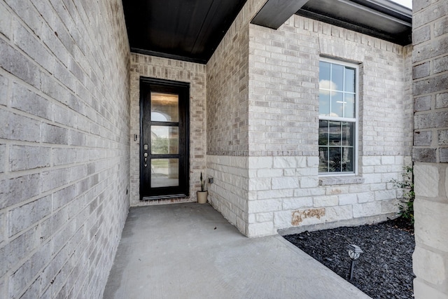 entrance to property featuring brick siding
