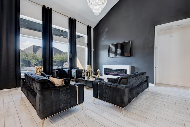 living room featuring high vaulted ceiling and an inviting chandelier