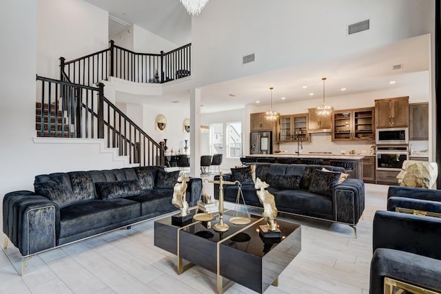 living room with visible vents, a high ceiling, stairway, and recessed lighting