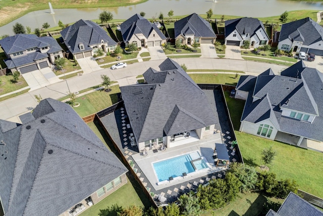 drone / aerial view with a water view and a residential view
