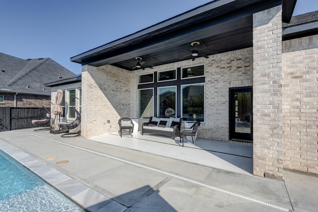 rear view of property with a fenced in pool, a patio area, fence, a ceiling fan, and brick siding
