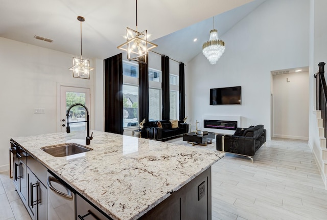kitchen featuring an inviting chandelier, a sink, visible vents, pendant lighting, and high vaulted ceiling