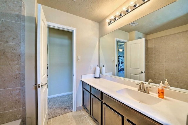 bathroom featuring tile patterned flooring, a textured ceiling, and vanity