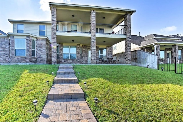 view of front of home featuring a front yard and a balcony