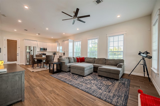 living room featuring ceiling fan, hardwood / wood-style floors, and sink