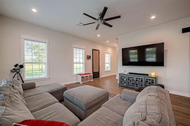 living room featuring wood-type flooring and ceiling fan