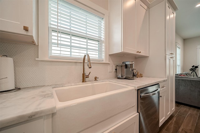 kitchen with dishwasher, white cabinetry, and sink