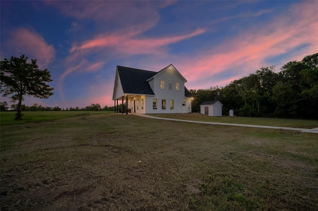 view of front of home with a yard and a storage shed