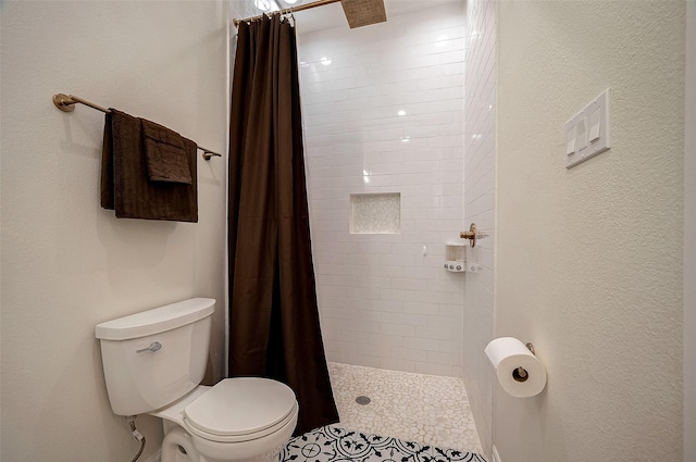 bathroom featuring a shower with curtain and toilet