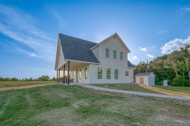 view of front facade featuring a front yard, a storage unit, and covered porch