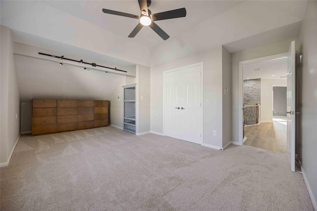 unfurnished bedroom featuring ceiling fan, light carpet, and a closet