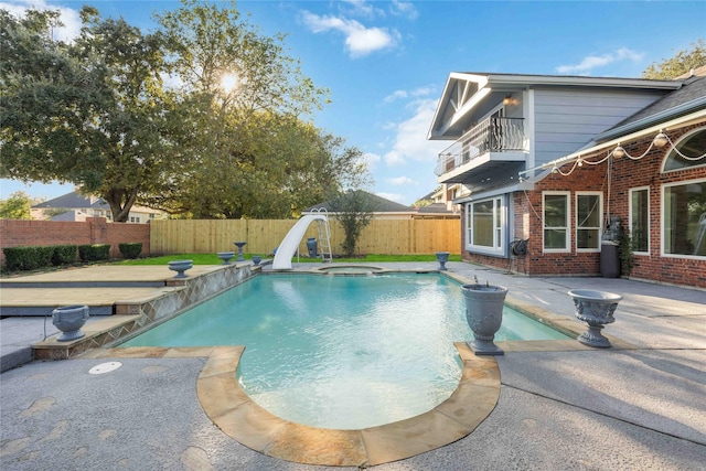 view of pool featuring a patio area, an in ground hot tub, and a water slide